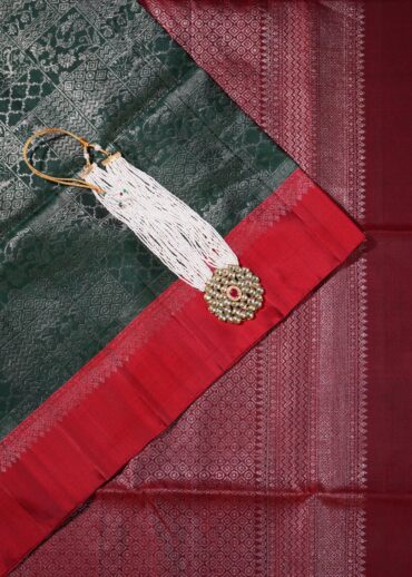 Soft silk saree with all over jaal brocade in bottle green with contrast red border and zari pallu.