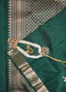 Kanjivaram saree in bottle green. Zari butta, zari border and zari pallu.