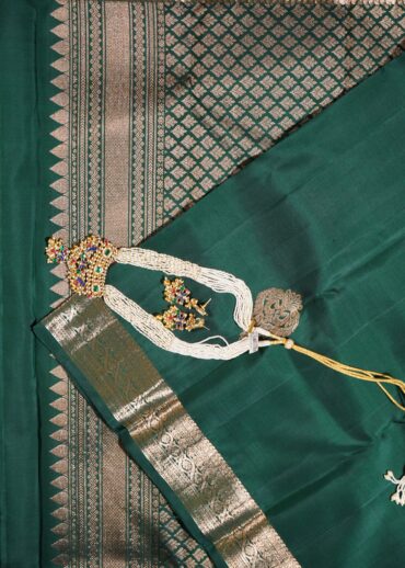 Kanjivaram saree in bottle green. Zari butta, zari border and zari pallu.