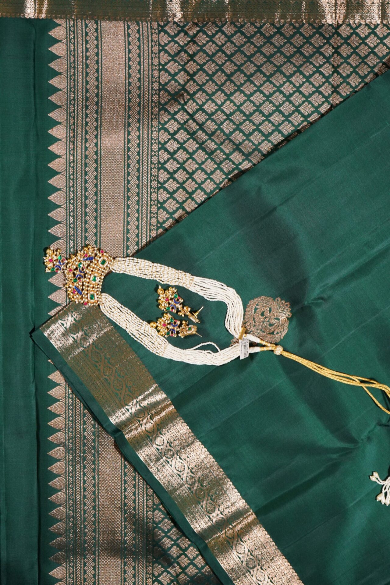 Kanjivaram saree in bottle green. Zari butta, zari border and zari pallu.